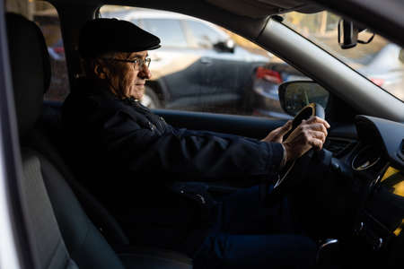 Smiling happy elderly man in the new carの写真素材