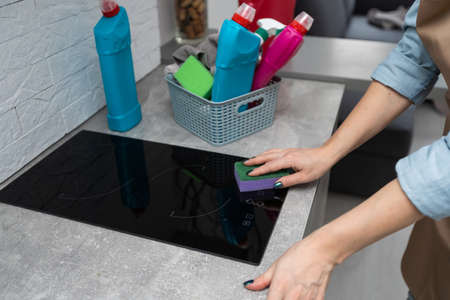 Cheerful Young Professional Cleaning Lady Wearing Apron Cleaning Stainless Steel Sink In Kitchenの写真素材
