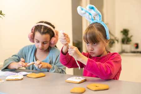 two little girls making gingerbread cookies at home.の写真素材