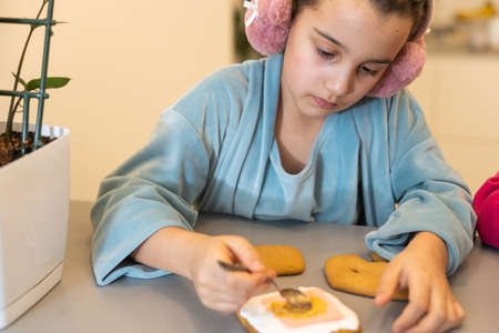 Girl decorates homemade gingerbread for Easterの写真素材
