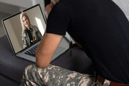 military using laptop online conference with familyの写真素材