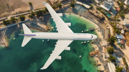 Airplane landing above beautiful beach and sea backgroundの写真素材