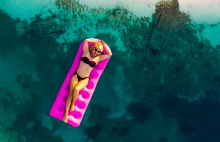 Woman on air mattress in the sea. Young woman on air mattress in the sea.の写真素材