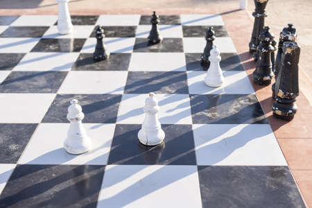 Large plastic chess set in the city park. Children playing big chess in the parkの写真素材
