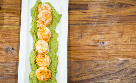baked prawns on sweet potato puree on a platter.の写真素材