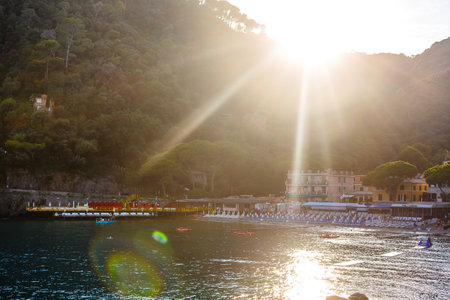 Fishing boats moored on water in harbor of Ligurian and Mediterranean Sea near coastline of Riviera di Levante of National park Cinque Terre Coast with blue sky, Riomaggiore village, Liguria, Italy.のeditorial素材