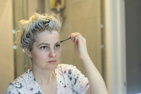 woman dyes her hair and eyebrows herself