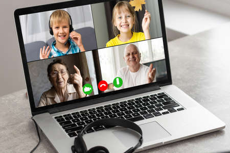 Virtual meeting with a friends. A guy is using laptop for video callの写真素材