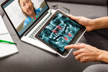 Discussing issues. Cropped shot of a professional dentist showing jaws and teeth x-rays to his...