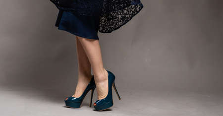 beautiful female legs in a skirt and heels.Young woman standing wearing high heelsの写真素材