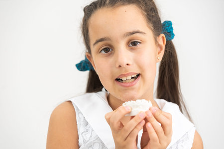 Teenager is holding a dental cast model at the start of orthodontic treatment alongside her teeth after the treatment was completed.の写真素材