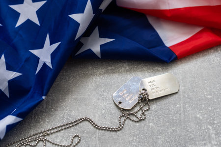 Army Dog tag token with 9mm bullets and pistol lie on folded United States flag