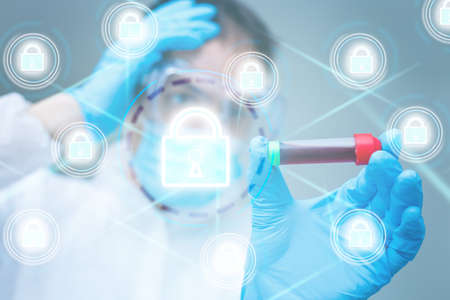 Unrecognizable doctor of medicine securing patient medical records across multiple devices via a computer network. Healthcare IT concept for security of health information exchange and data privacy.の写真素材