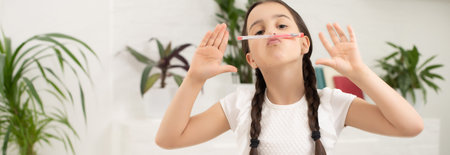 Smart little schoolgirl with pen and books writing a test in a classroom. Child in an elementary...