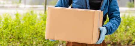 delivery man in a medical mask and gloves delivers the parcel. Quarantine, coronavirus, isolationの写真素材