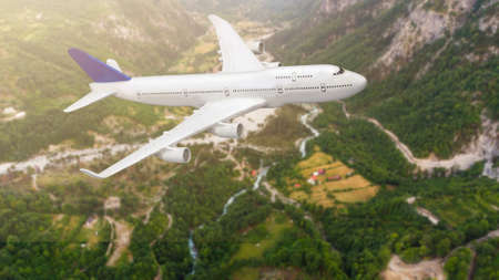 Aerial view of aircraft. Airplane is flying over mountains with forest. Business travel. Commercial planeの写真素材