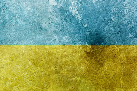 Grunge Ukrainian national flag pattern on broken weathered dirty concrete wall with cracks background, abstract Ukraine politics conflicts concept pattern texture wallpaperの写真素材