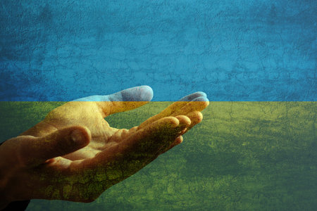 Pray for ukraine. hands pray on ukraine flagの写真素材