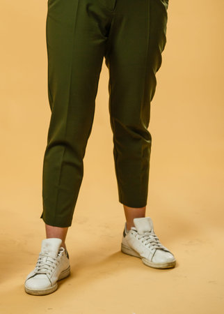 girl in sneakers, posing near the wall on a warm summer night. Warm color.の写真素材