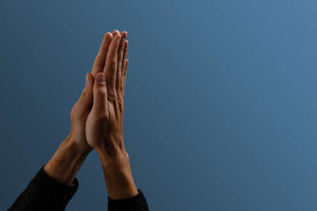 Praying hands with faith in religion and belief in God on dark background. Power of hope or love and devotion. Namaste or Namaskar hands gesture. Prayer positionの写真素材