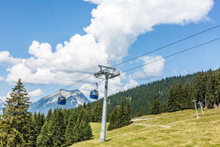 Ski lift in summer. Cable car. View from the mountain. Beautiful landscape. Ski track in summer. Funicular. Mountainous terrain.の写真素材