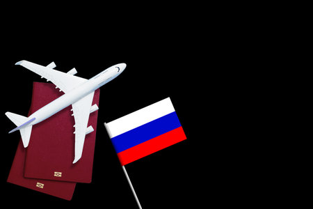 Russian flag, toy plane and barbed wire on blue background, concept of banning aircraft departing...