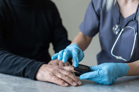 Elderly people measuring their pulse with their fingertips at a long-term care facilityの写真素材