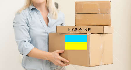 Volunteer cyrrying box with Humanitarian aid for Ukrainian refugees in streetの写真素材