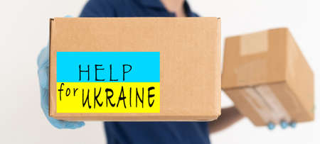 Volunteer cyrrying box with Humanitarian aid for Ukrainian refugees in streetの写真素材