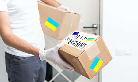 Close up of volunteer cyrrying box with Humanitarian aid for Ukrainian refugees in streetの写真素材