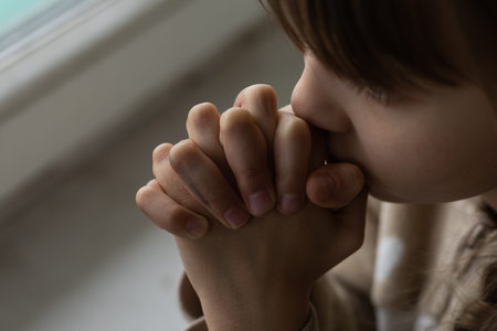 Little girl praying on the white table in the morning. Little girl hand praying, Hands folded in...