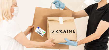 Volunteers collecting donations for the needs of Ukrainian migrants, humanitarian aid concept.の写真素材