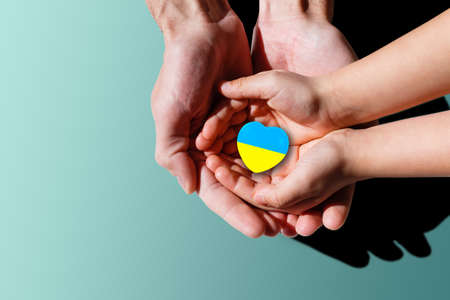 The national flag of ukraine with the coat of arms in female hands. Flat lay, copy spaceの写真素材