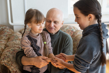 Hands of the old man and a childs hand.
