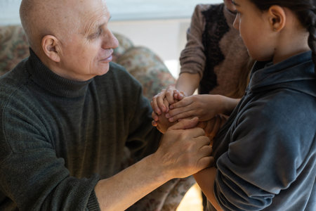 hands of grandfather and granddaughter with prayer