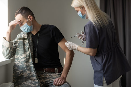 Soldier in uniform receiving vaccine shot against virus at the clinic. Military vaccination and...