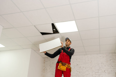 Builder replacing ceiling panel, working, ceiling armstrongの写真素材