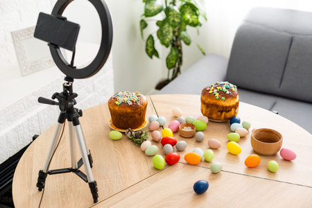 A smartphone on a table festively decorated for the Easter holiday. Adorned working place with...