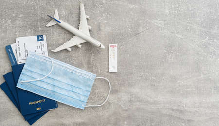 Syringe, toy plane, medical mask and passport with certificate of vaccination with text Covid-19 Vaccinated inside it. Travel concept during the Covid-19 pandemic.の写真素材
