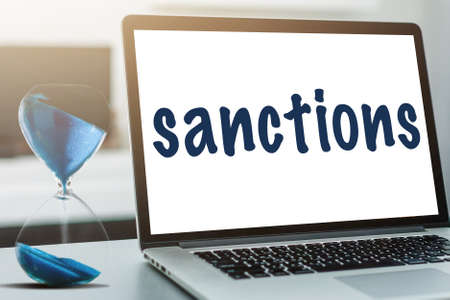 The word sanctions is written on notebook. Political and economic conceptの写真素材