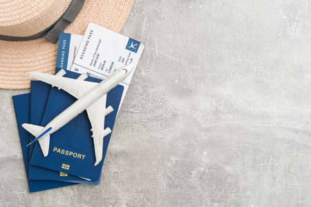 Travel and vacation concept. Trip accessories and items. Airplane toy over passport with airplane tickets and face masks. Top view flat lay with copy space.の写真素材
