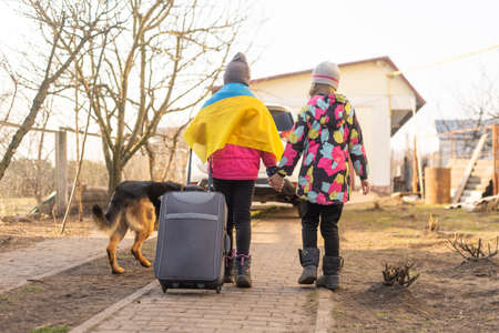 Ukraine military migration. two little girls with a suitcase. Flag of Ukraine, help. Crisis, military conflictの写真素材