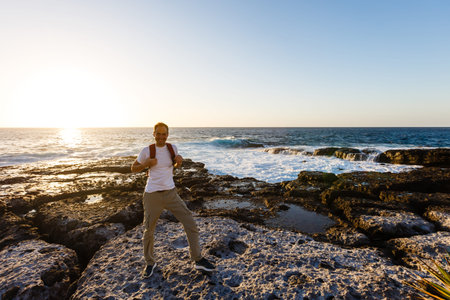 young bright attractive man standing on the ocean and controlling the situation on the beach. Ocean...