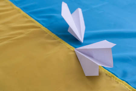 Save Ukraine. Two paper airplanes with the flag of Ukraine, help and charity. Art collage.の写真素材