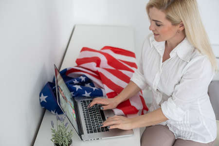woman with laptop and usa flag. Foreign languages learning, educational online courseの写真素材