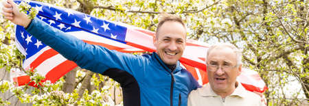 July 4th: American Family Behind US Flagの写真素材