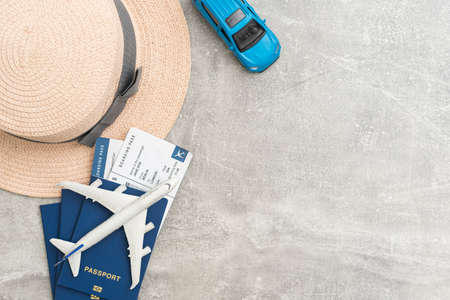 Travel and vacation concept. Trip accessories and items. Airplane toy over passport with airplane tickets and face masks. Top view flat lay with copy space.の写真素材