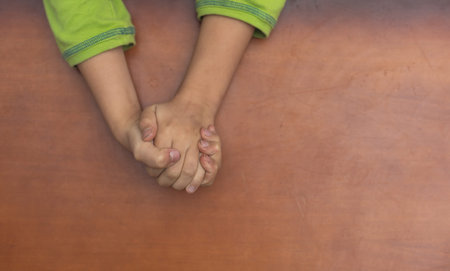 Childs hands folded together in prayer