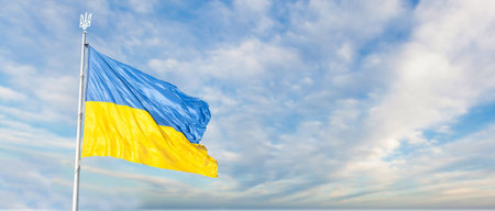 Large national flag of Ukraine flies in the blue sky. Big yellow blue Ukrainian state banner....
