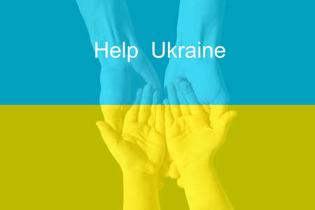 childrens small hands hold female hands painted in yellow and blue colors of Ukrainian flag. Family together, peace, care. Support Ukrainians during the war on territory of Ukraine.の写真素材